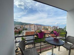 uma varanda com uma mesa e cadeiras e uma vista em Guest's Apartament em Pogradec