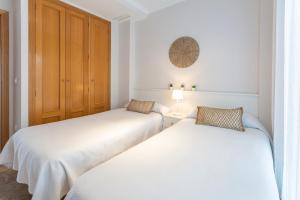 twee bedden in een kamer met witte muren bij AG RESIDENCIAL EL EDEN in Playa de Gandia +82 foto's