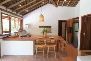 cocina con mesa de madera y sillas en Pousada Outeiro, en Praia do Espelho