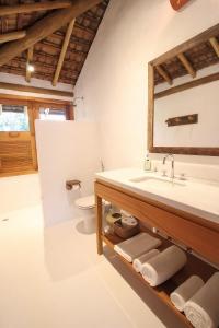 a bathroom with a sink and a toilet at Pousada Outeiro in Praia do Espelho