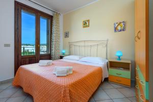 una camera da letto con un letto e una grande finestra di I Tre Golfi - Appartamenti con Terrazzo fino a 800 mt dal mare a San Vito lo Capo
