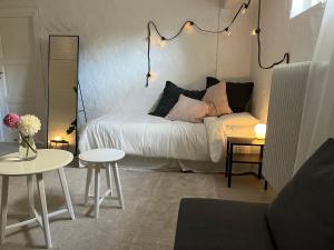 uma sala de estar com uma cama e duas mesas em Central living with many beds and private garden! em Gotemburgo