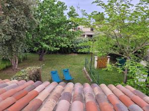 deux chaises bleues assises au-dessus d'un toit dans l'établissement Mini villa au bord de la mer, proche Moriani (Corse), à Poggio-Mezzana