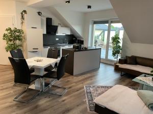 a kitchen and living room with a table and chairs at Sorinas Home - Comfortable Apartment near Graz - Free Parking in Wagersbach