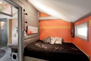 ein kleines Bett in einem Zimmer mit orangefarbener Wand in der Unterkunft Torppa Stengård 1700-luvulta in Porvoo