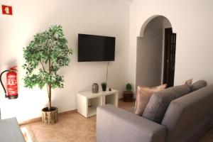 un soggiorno con un divano e una TV a parete di Casinha da Ria ad Alvor