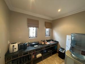 a kitchen with a counter and a refrigerator at ARK Guesthouse in Potchefstroom