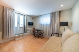 a living room with a bed and a table and a window at CASA RIETSCH in Matosinhos