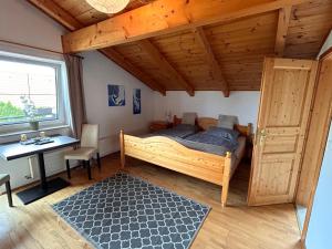 a bedroom with a bed and a desk and a window at Casa Boebelle 3 km von der Therme Bükfürdö in Bük