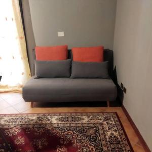 a couch with two orange pillows in a living room at La Cueva in Imola