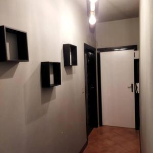 a hallway with a white wall with a door and speakers at La Cueva in Imola