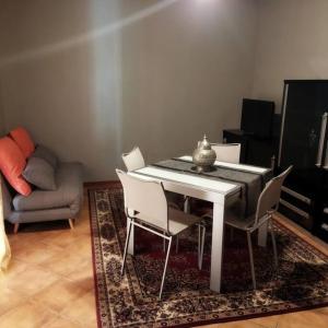 salon z białym stołem i krzesłami w obiekcie La Cueva w mieście Imola