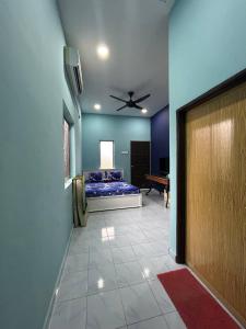 Cette chambre comprend un lit et un ventilateur de plafond. dans l'établissement Mahasa Penarik Homestay, à Kampong Ru Sepuloh