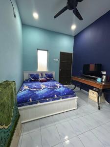 a bedroom with a bed and a television and a ceiling fan at Mahasa Penarik Homestay in Kampong Ru Sepuloh