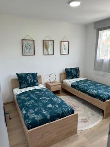 a bedroom with two beds and a rug at Gîte d'Esila in Saint-Aignan