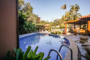 uma piscina ao lado de um edifício com um resort em Corais e Conchas em Búzios