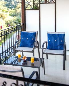 due sedie e un tavolo su un balcone con succo d'arancia di OUTParga Apartment 4 a Párga