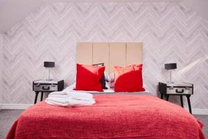 1 dormitorio con cama roja y almohadas rojas en The Exquisite Manchester Abode - Parking, en Mánchester