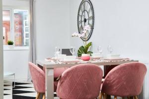 comedor con mesa y sillas rosas en The Exquisite Manchester Abode - Parking, en Mánchester