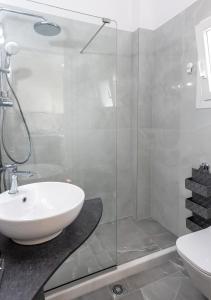 un bagno con lavandino e doccia in vetro di OUTParga Apartment 4 a Párga Altre 31 foto