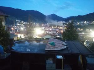 a hot tub with a view of a city at night at Rodope Nook Guest house in Chepelare