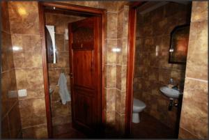 a bathroom with a wooden door and a sink at Dom Pod Dębem in Majdy