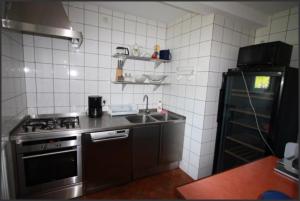 a kitchen with a stainless steel sink and a stove at Dom Pod Dębem in Majdy