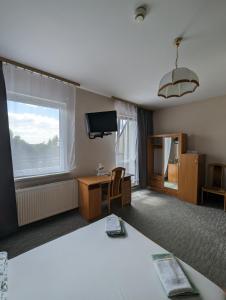 a room with a bed and a desk and a television at Motel DRABEK in Tarnowskie Góry