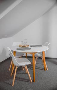 uma mesa branca com duas cadeiras e uma mesa com copos em The Dom 21 em Cluj-Napoca