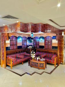 a living room with red couches and a table at Benta Grand Hotel LLC in Dubai