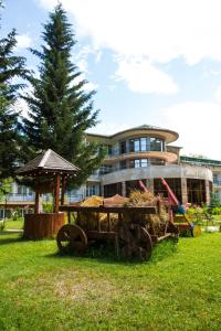a cart of hay sitting in the grass in front of a building at Cennet Bagi Guba Hotel in Quba