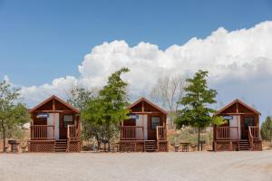 a group of cottages with tables and trees at Sun Outdoors Canyonlands Gateway in Moab