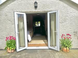 una puerta abierta de una casa con flores rosas en Meadow View en Mayfield