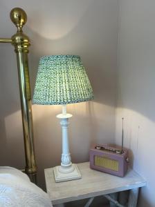 a lamp sitting on a table next to a bed at Meadow View in Mayfield