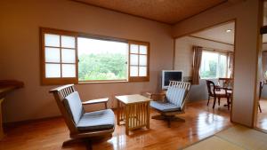 uma sala de estar com duas cadeiras e uma mesa em Shikisai no Sato Manyu em Kirishima