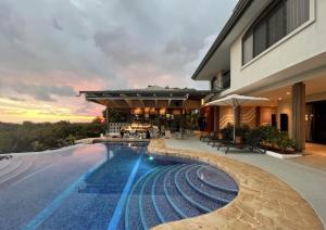 a swimming pool in front of a building at Marala Hotel in Esterillos