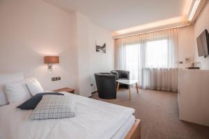 a bedroom with a bed and a chair and a window at Chalet Alpenstern in Oberstdorf