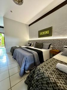 a bedroom with two beds and a rug at Recanto Verde Praia Hotel Juquehy in Juquei