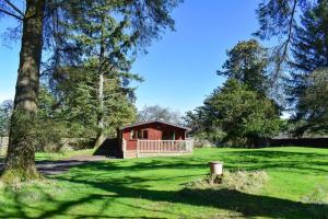 una cabaña en medio de un campo verde en Secluded Pine Lodge 1 en Carlisle