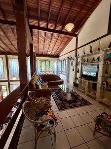 a living room with a couch and a tv at Recanto Verde Praia Hotel Juquehy in Juquei