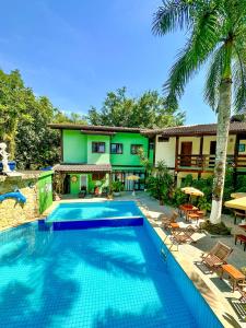 a swimming pool in front of a house at Recanto Verde Praia Hotel Juquehy in Juquei