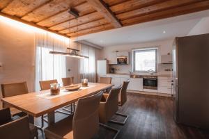 uma cozinha e sala de jantar com uma mesa de madeira e cadeiras em Chalet Alpenstern em Oberstdorf