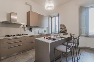 a kitchen with a island with chairs and a counter top at [5 min Historic Center] Luxury White Lotus Mansion in Como
