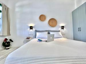 una camera con un letto bianco e un computer portatile di Nikiforos Boutique apartment a Naxos Chora