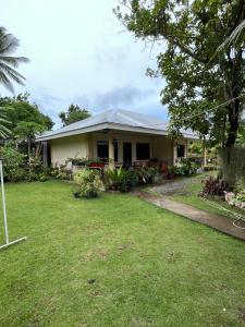 a house with a lawn in front of it at Veance Travellers Inn-Pabuas extension in Mambajao