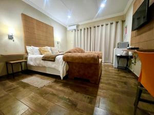 um quarto com uma cama e uma cadeira em Swane’s guesthouse em Rustenburg
