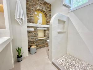 a bathroom with a toilet in a stone wall at Nikiforos Boutique apartment in Naxos Chora