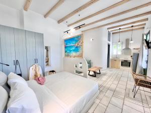 a bedroom with a large white bed and a kitchen at Nikiforos Boutique apartment in Naxos Chora