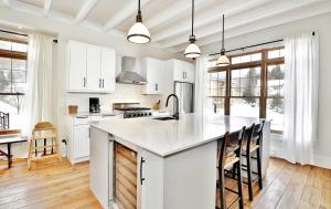 a kitchen with white cabinets and a large kitchen island at Chalet 9023 Chemin des Alpages by Les Chalets Alpins in Stoneham