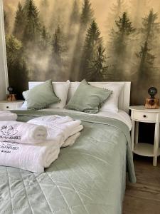 a bedroom with a bed with a forest mural on the wall at Ironland Roztocze 